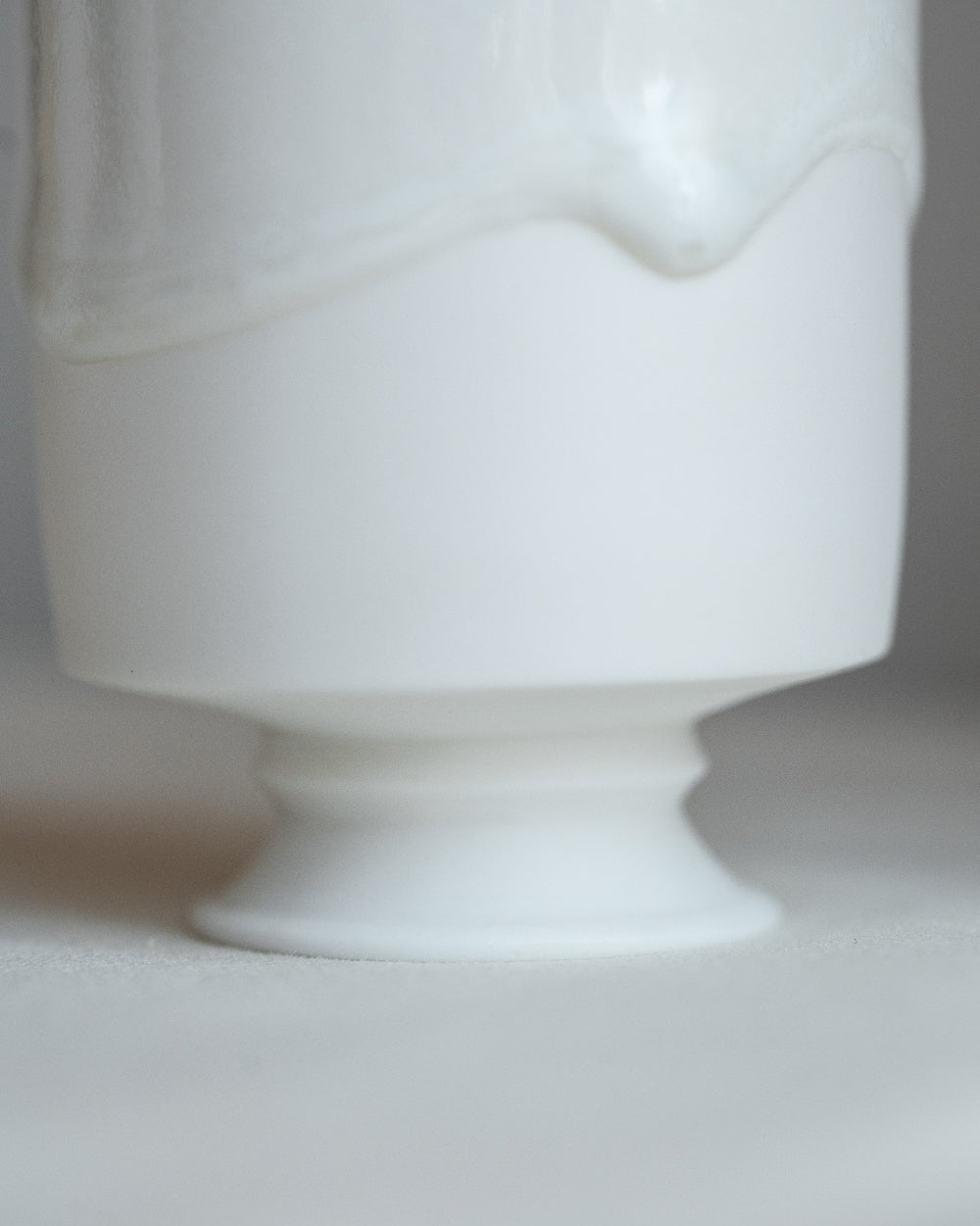 White ceramic footed dish on a light gray background
